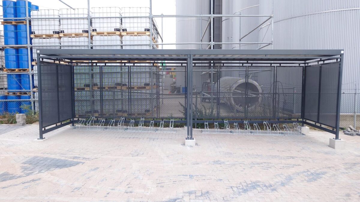 Moderne fietsoverkapping Hagen en rookoverkapping Myla geplaatst bij De Klerk in Werkendam 1 Vooraanzicht van een moderne fietsoverkapping Hagen met FR1000 fietsenrekken op het bedrijfsterrein van De Klerk in Werkendam.
